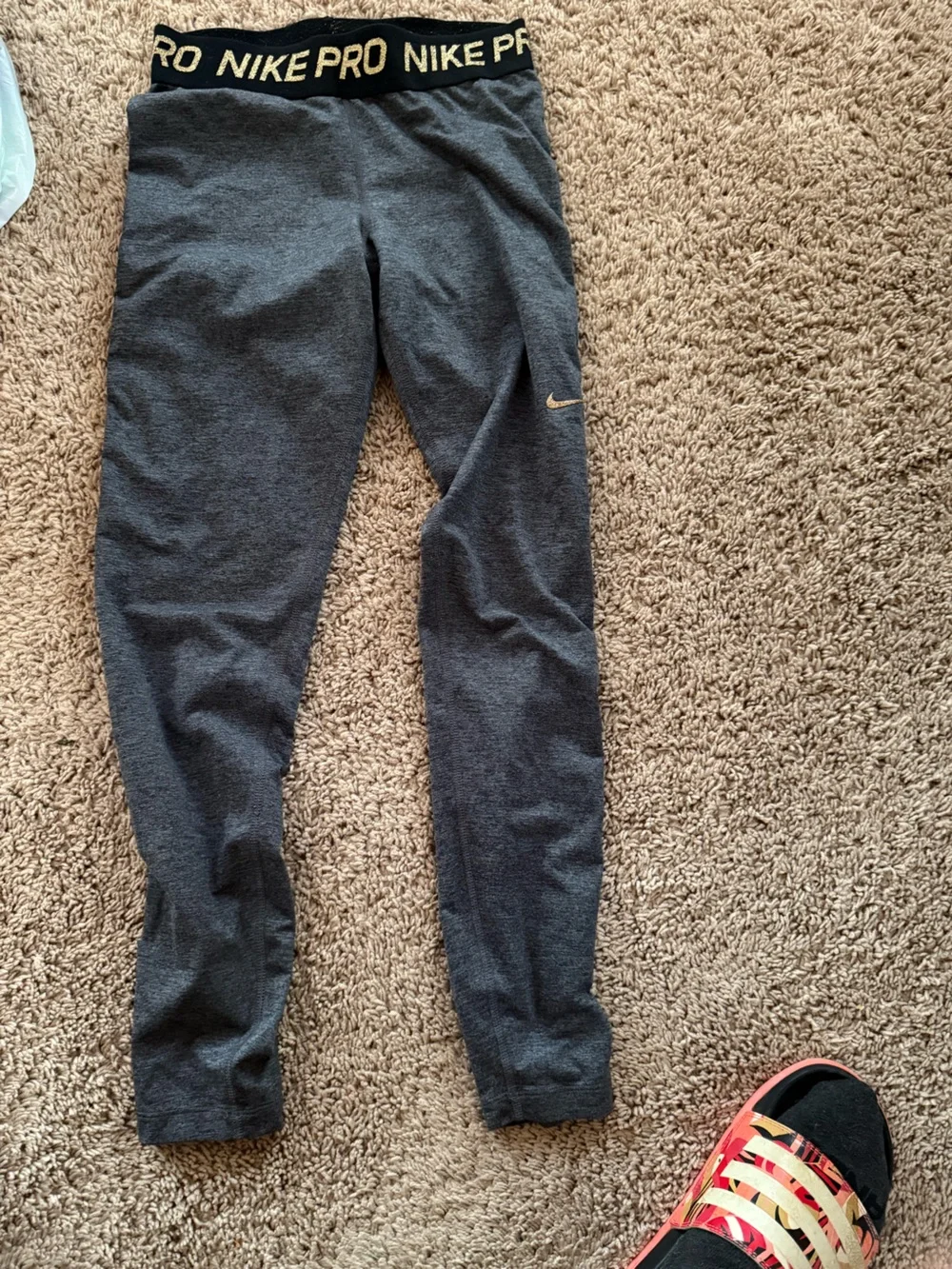 Nike women’s Charcoal Gray leggings with gold Swoosh